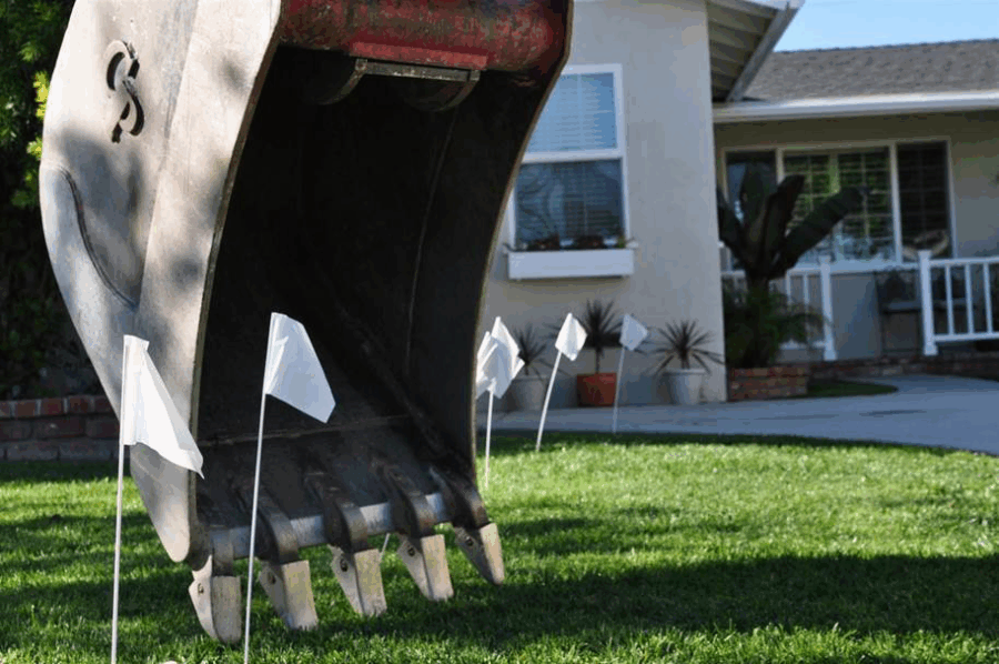 backhoe with locate flags for utilities nearby